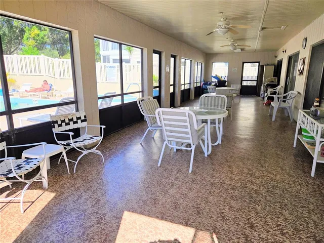a dining room with furniture large windows and a rug
