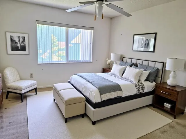 a spacious bedroom with a bed and a chair