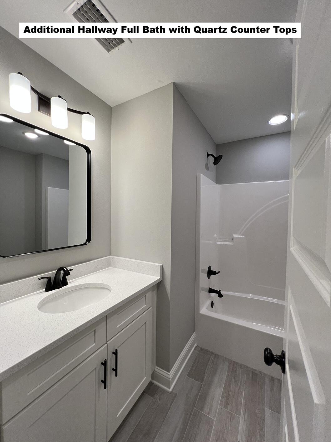 4644 Chanteuse Parkway Crestview, FL 32539 - Photo 18 of 34 a bathroom with a sink a mirror and a bathtub
