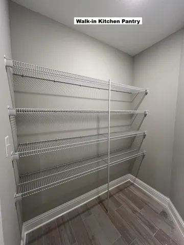 a view of a kitchen with kitchen island wooden floors wooden floor and appliances