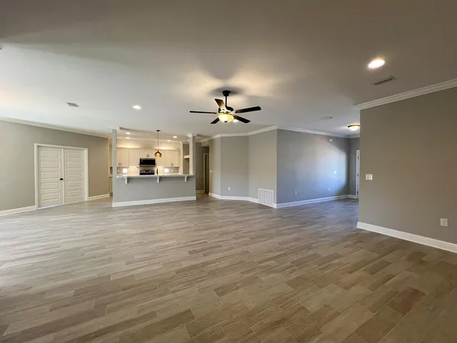 a view of an empty room with wooden floor