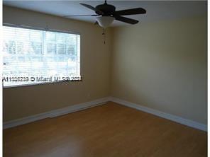 a view of a room with a window and a ceiling fan