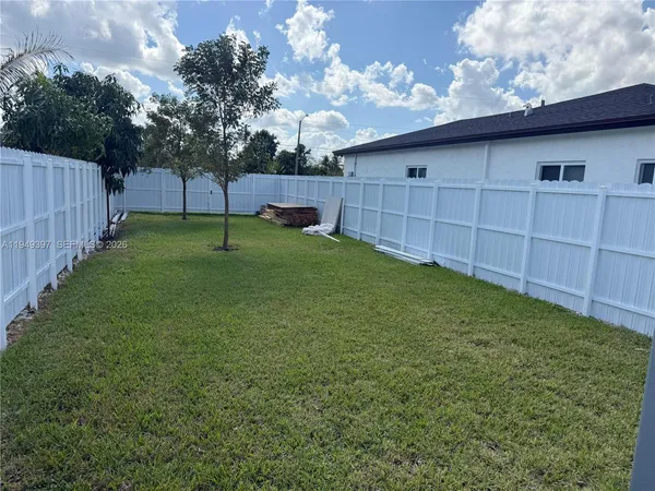 a view of backyard with wooden fence