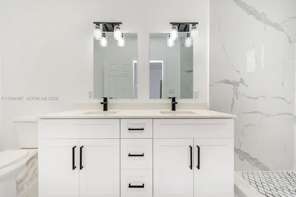 a bathroom with double vanity sink and a mirror