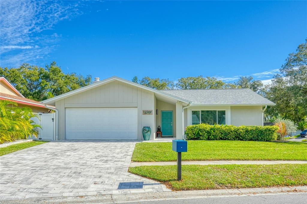 a front view of a house with garage and plants