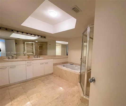 a large bathroom with a sink a large mirror and a bathtub