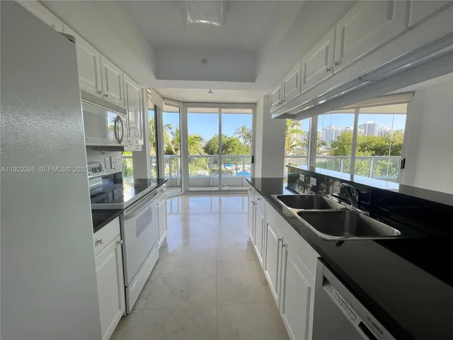 a kitchen with granite countertop a sink and a refrigerator