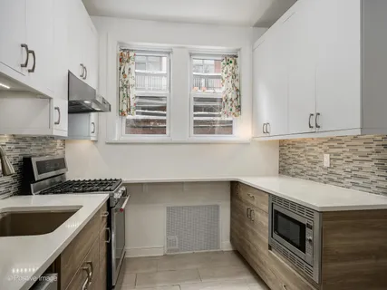 a kitchen with granite countertop a sink stainless steel appliances and cabinets