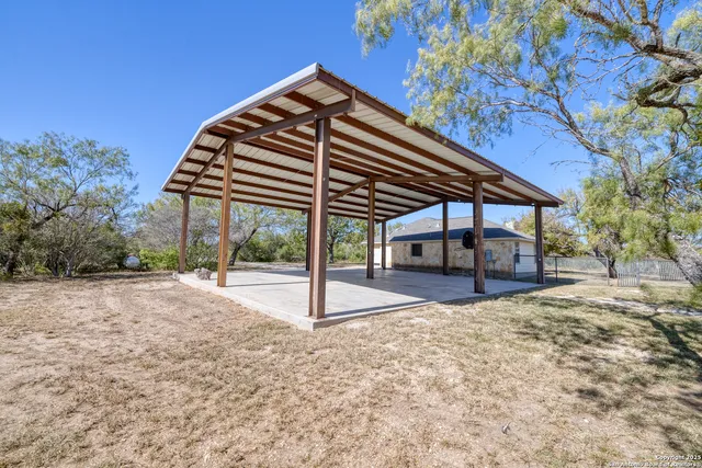 a view of a house with a yard and wooden fence