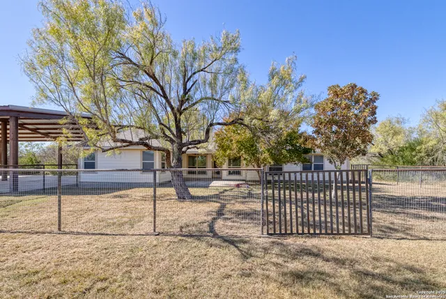 a view of a yard with wooden fence