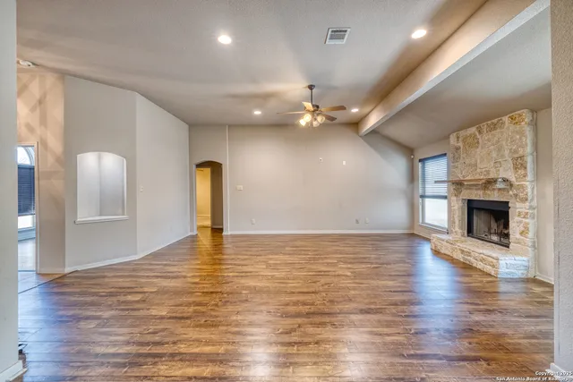 a view of an empty room with a fireplace and window