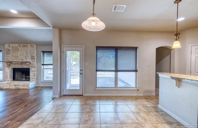 a view of an empty room with window and fire place