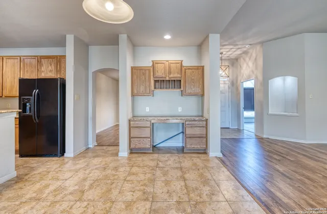 a large kitchen with stainless steel appliances kitchen island granite countertop a refrigerator and a sink