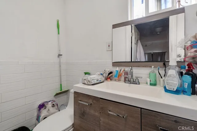 a bathroom with a sink a toilet and mirror