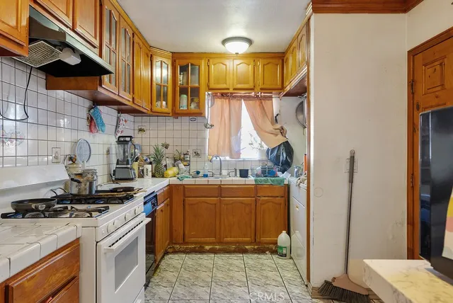 a kitchen with stainless steel appliances granite countertop a stove a sink and a refrigerator