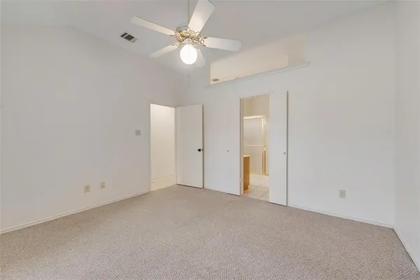 an empty room with a ceiling fan and a fan