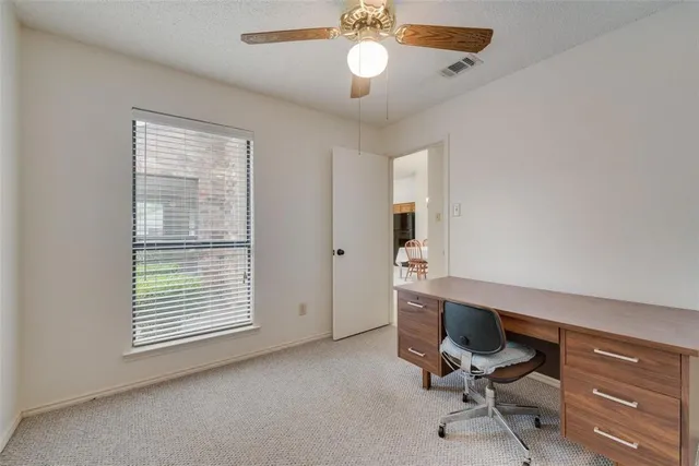 a view of a workspace with furniture and a window