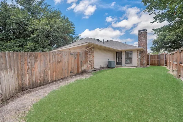 a view of a house with a small yard and wooden fence
