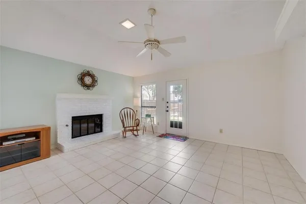 an empty room with windows and fireplace