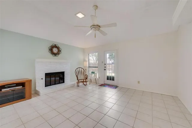 an empty room with windows and fireplace