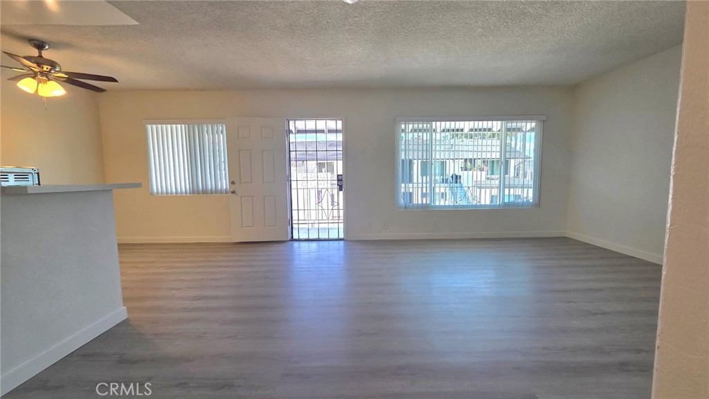 1803 West Sumac Lane, Unit 5 Anaheim, CA 92804 - Photo 4 of 18 an empty room with wooden floor and windows