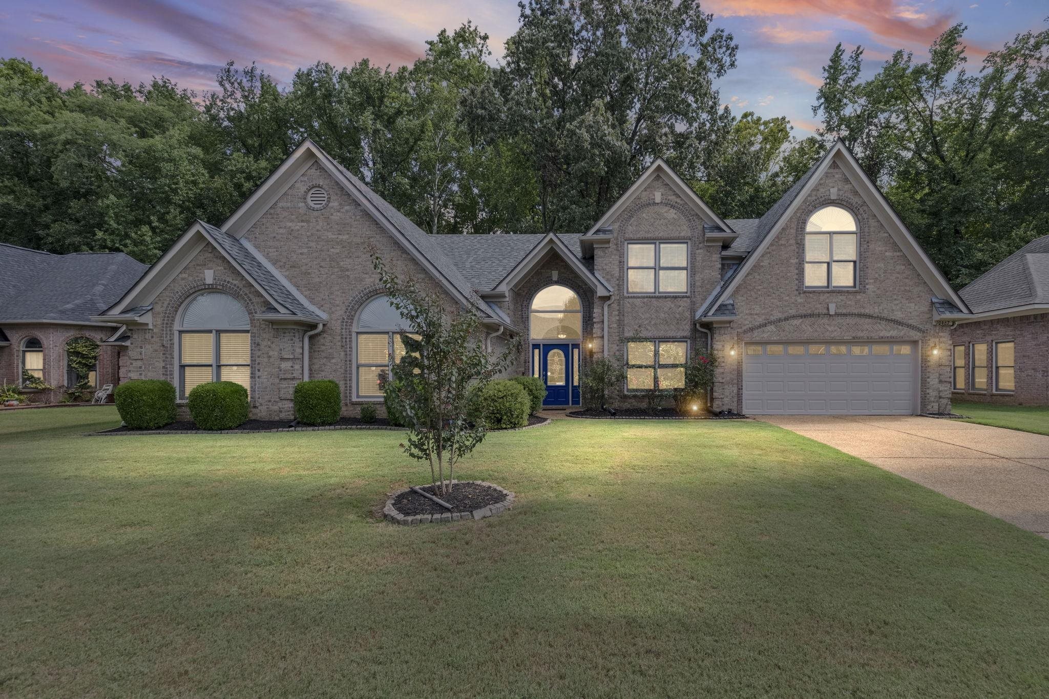 10467 Juneau Way Collierville, TN 38017 - Photo 2 of 34 a front view of a house with a garden and porch