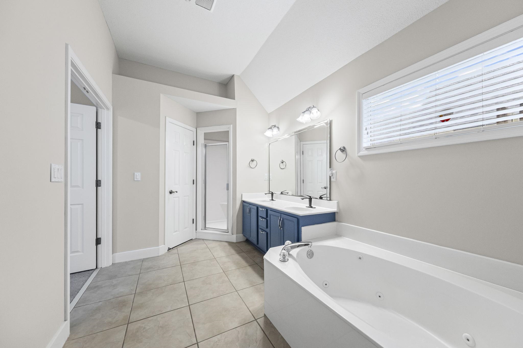 10467 Juneau Way Collierville, TN 38017 - Photo 21 of 34 a bathroom with a bathtub a mirror a sink and shower