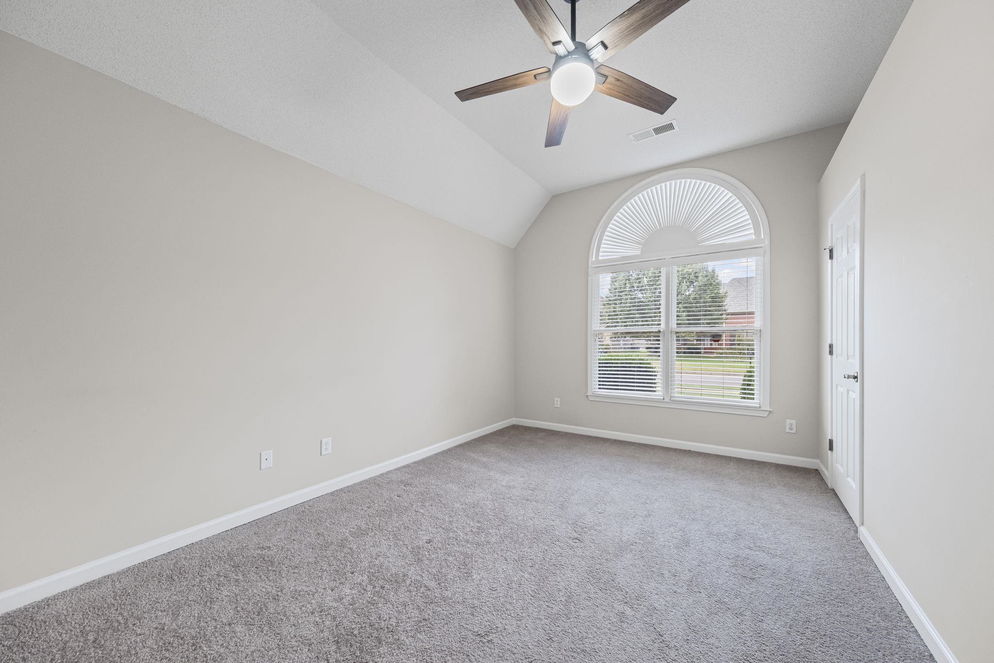 10467 Juneau Way Collierville, TN 38017 - Photo 22 of 34 an empty room with a chandelier fan and windows