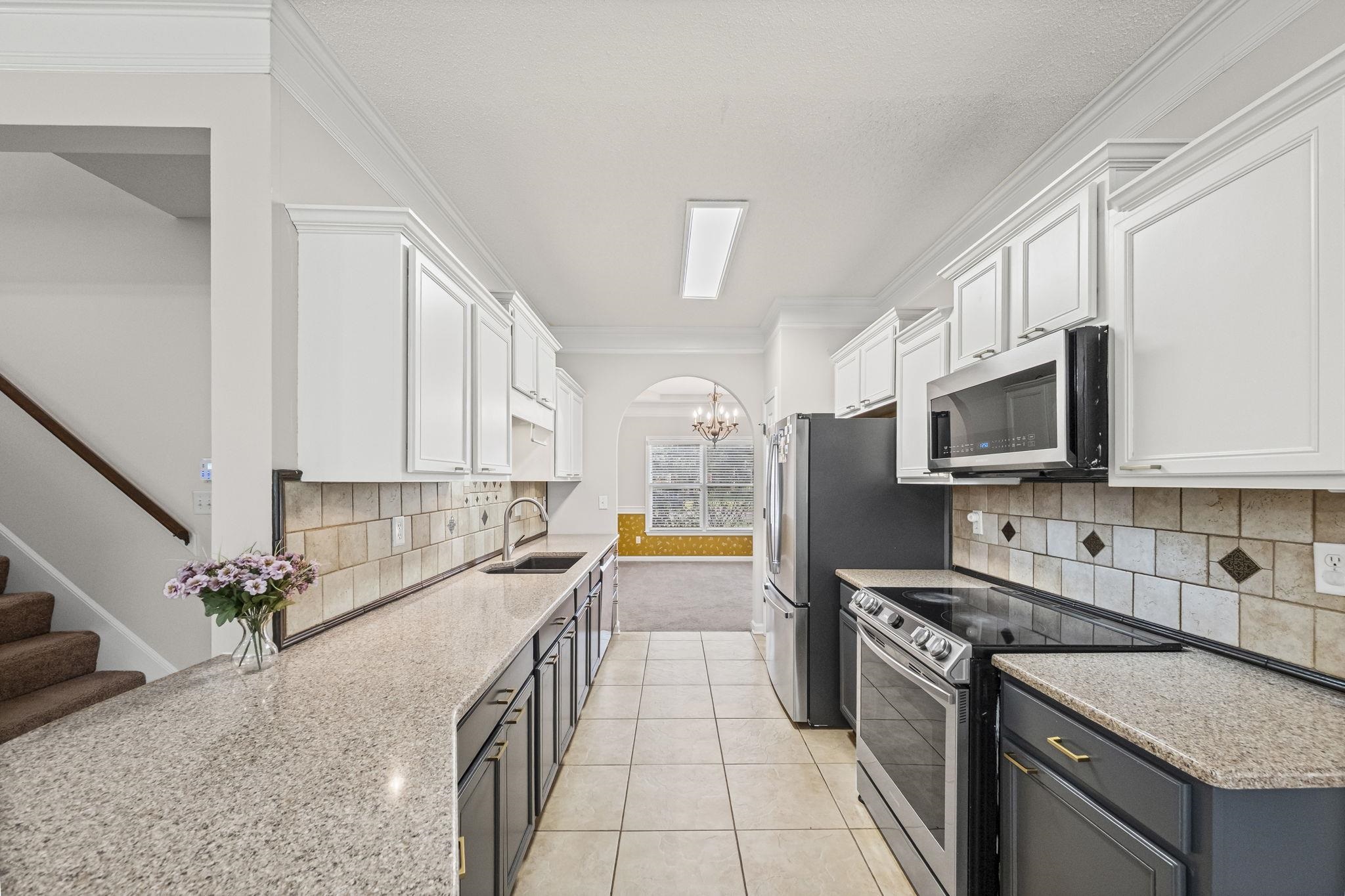10467 Juneau Way Collierville, TN 38017 - Photo 8 of 34 a kitchen with stainless steel appliances granite countertop a sink stove and refrigerator