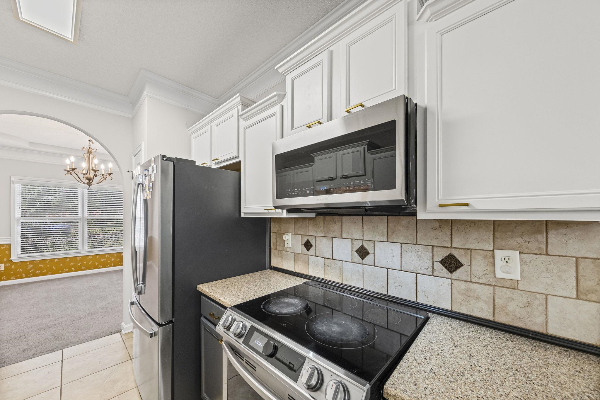 10467 Juneau Way Collierville, TN 38017 - Photo 10 of 34 a kitchen with stainless steel appliances granite countertop a refrigerator and a stove top oven