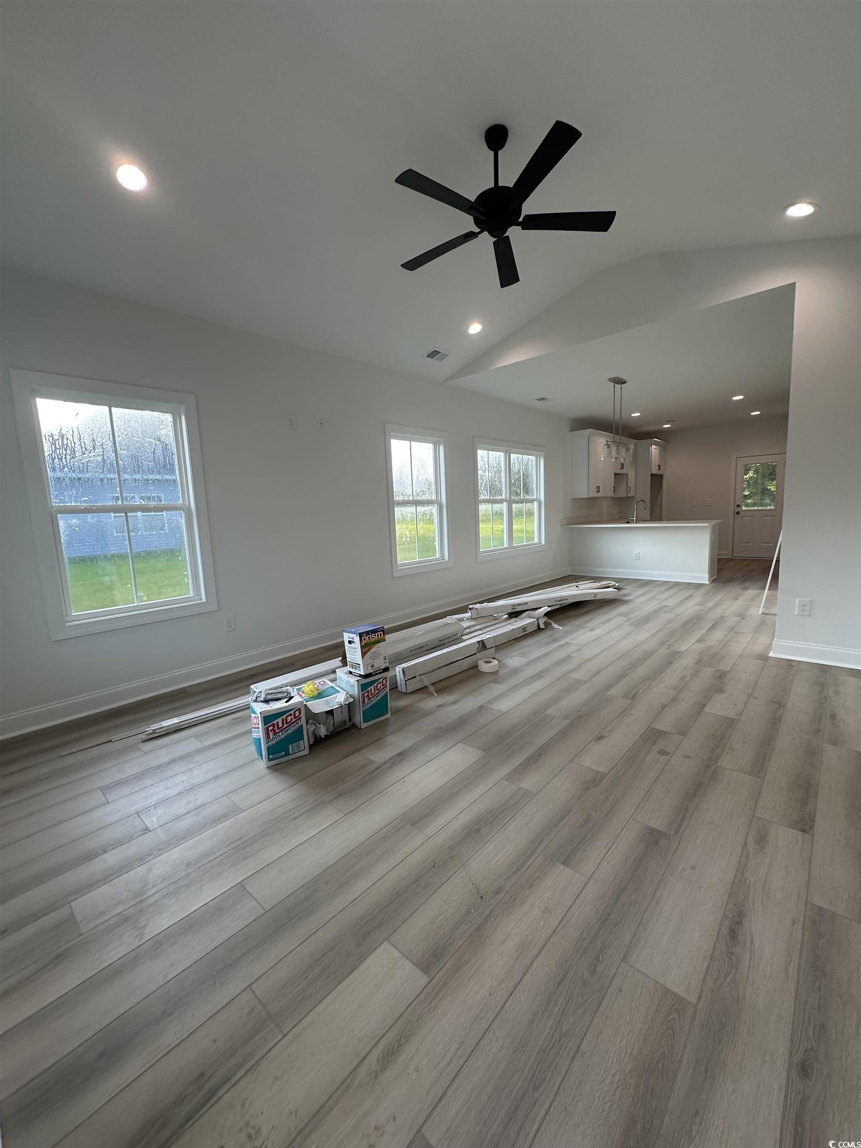 Unfurnished living room featuring lofted ceiling,