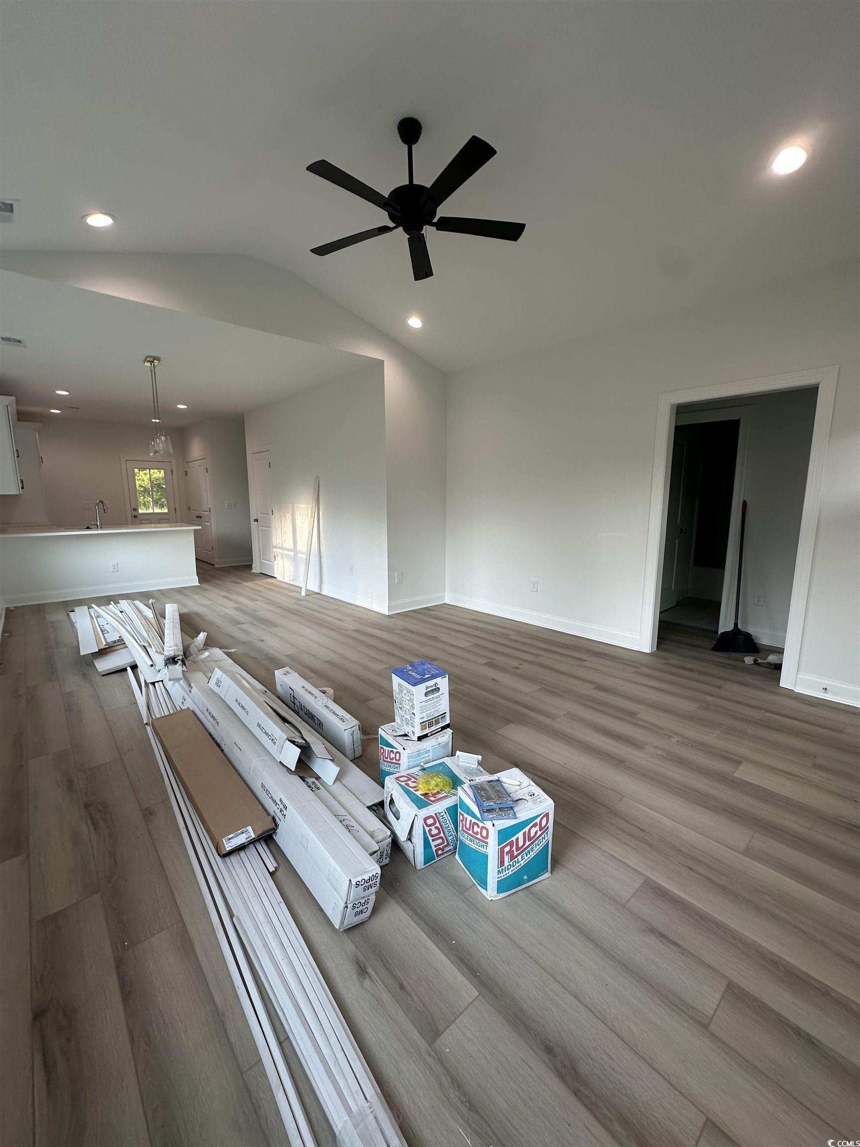 Unfurnished living room with lofted ceiling, hardw