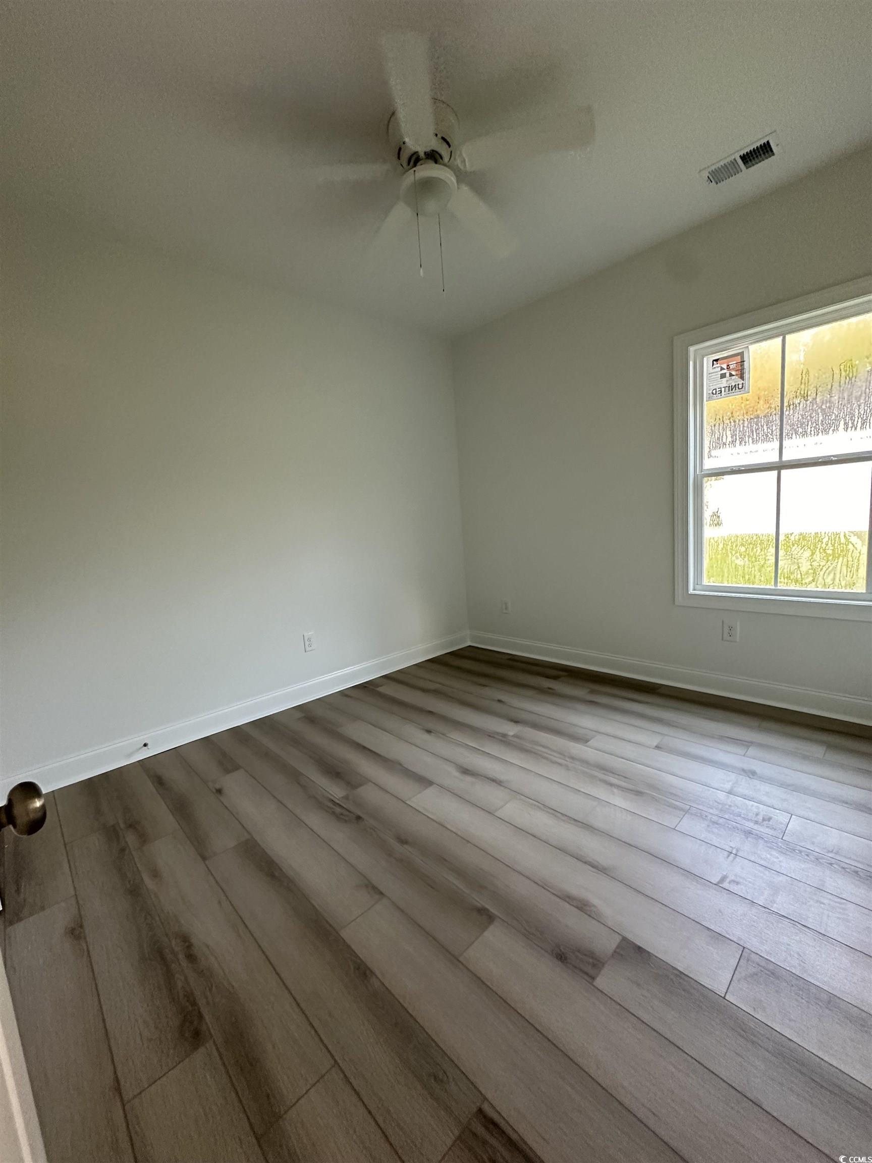 Spare room with ceiling fan and light hardwood / w