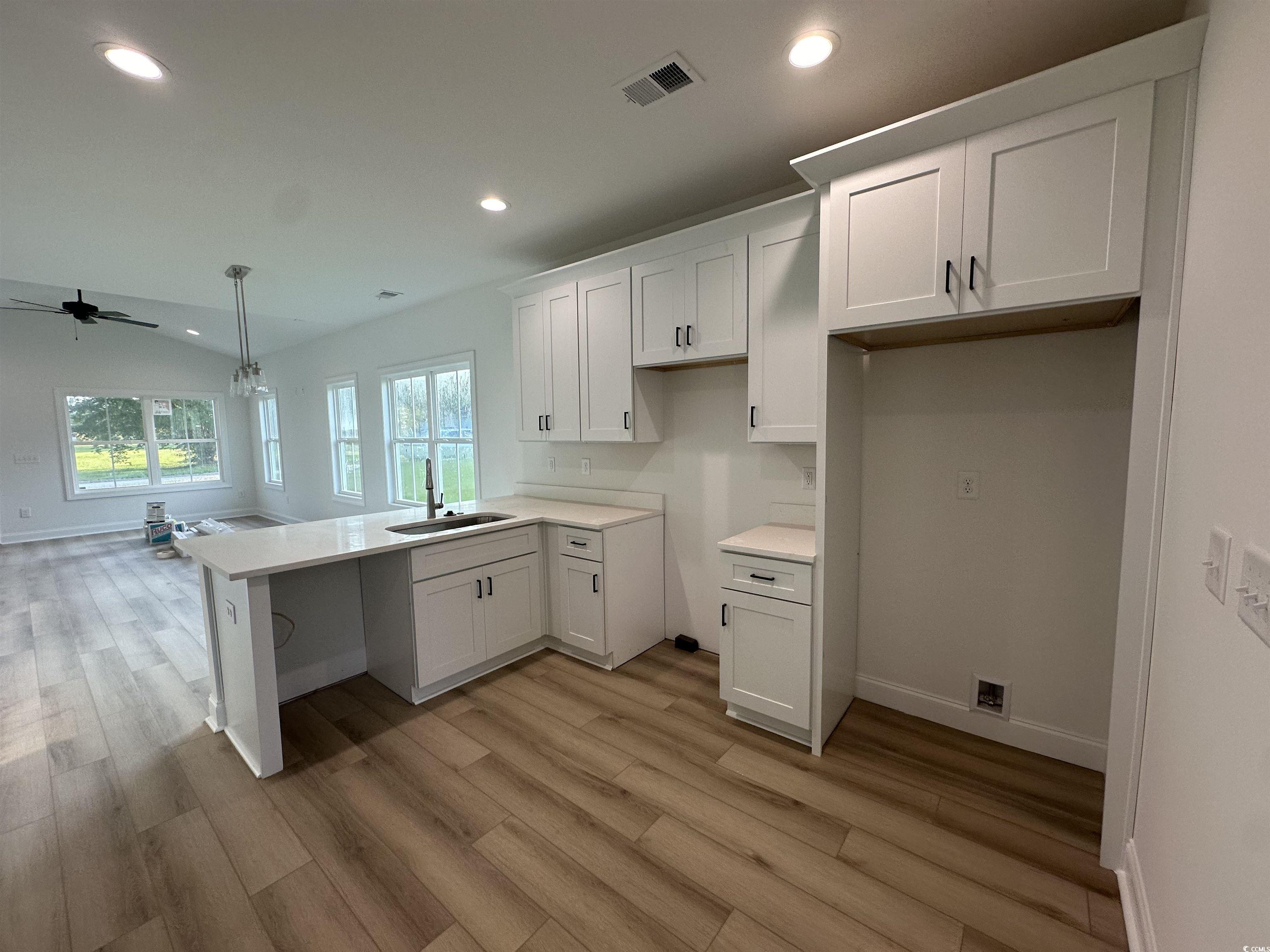 3474 Alton Road Loris, SC 29569 - Photo 9 of 16 Kitchen with sink, ceiling fan, white cabinets, an