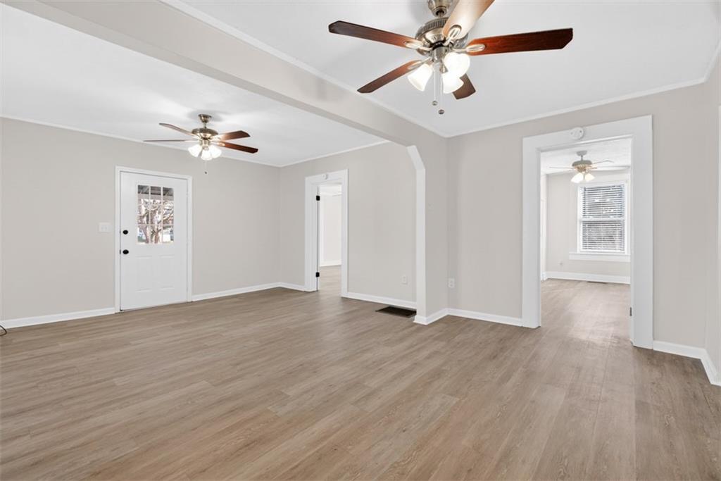 246 Spring Street Commerce, GA 30529 - Photo 6 of 23 a view of an empty room with window a ceiling fan and wooden floor