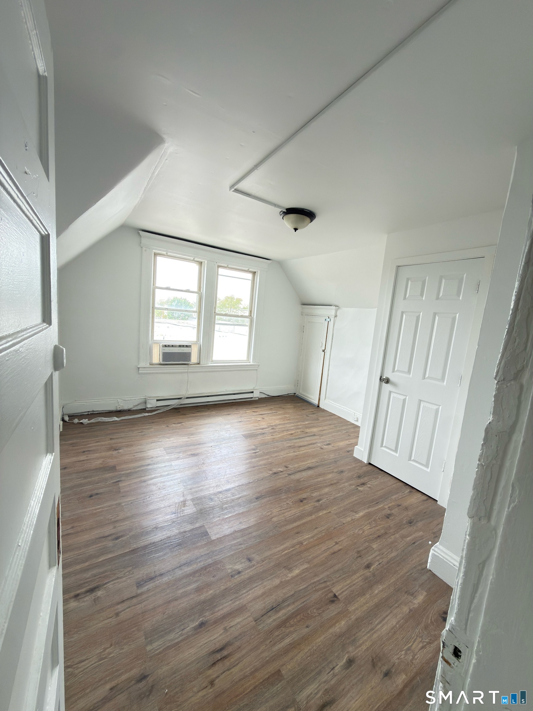 10 Beatrice Street, Unit 3 Bridgeport, CT 06607 - Photo 2 of 6 an empty room with wooden floor and windows