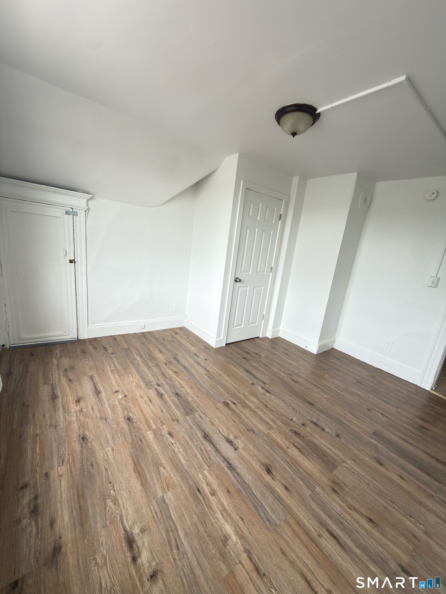 10 Beatrice Street, Unit 3 Bridgeport, CT 06607 - Photo 4 of 6 a view of empty room with wooden floor and fan