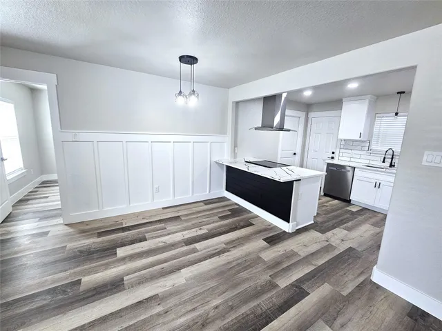 a living room with stainless steel appliances kitchen island granite countertop a sink and cabinets