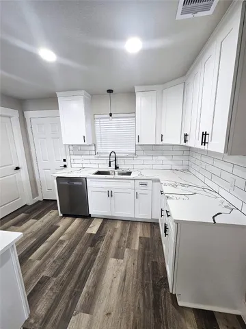 a kitchen with a sink a stove cabinets and a window