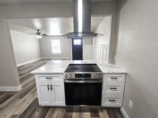 a kitchen with a stove and white cabinets