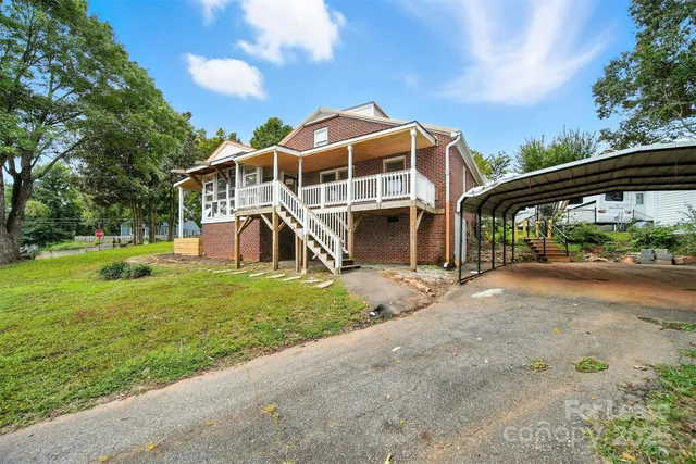 a view of a house with a yard and sitting area