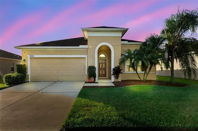 a front view of a house with a garden and plants