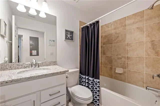 a bathroom with a granite countertop sink toilet mirror and bathtub