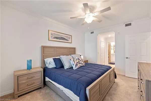 a bedroom with a large bed and a chandelier