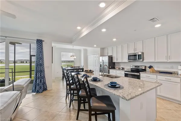 a kitchen with a dining table chairs and refrigerator