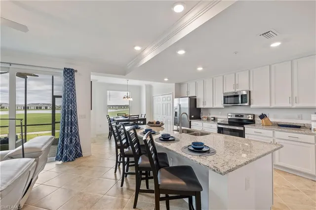 a kitchen with a dining table chairs and refrigerator