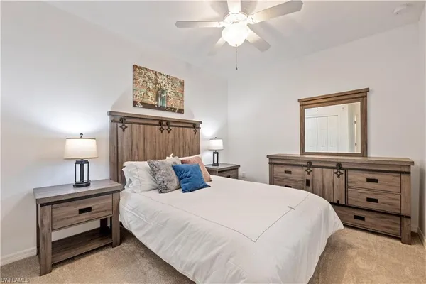 a bedroom with a bed and a lamp on dresser