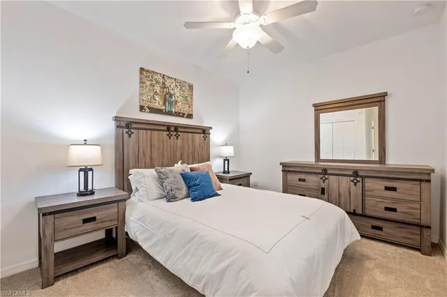 a bedroom with a bed and a lamp on dresser