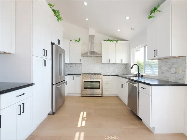 a kitchen with white cabinets and stainless steel appliances