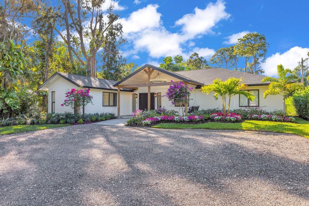a front view of house with outdoor space and trees